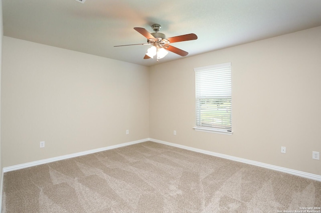 empty room featuring ceiling fan and light colored carpet