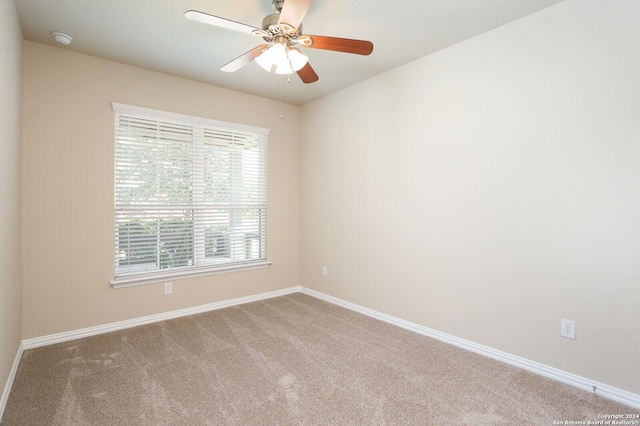 carpeted spare room with ceiling fan