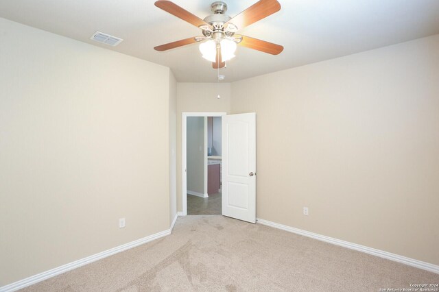 carpeted empty room featuring ceiling fan