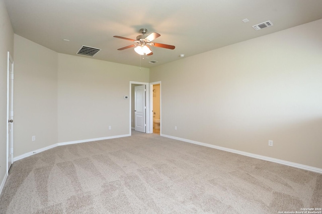 spare room featuring light carpet and ceiling fan