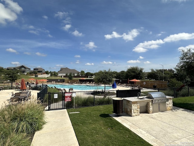 view of pool featuring area for grilling, a yard, grilling area, and a patio