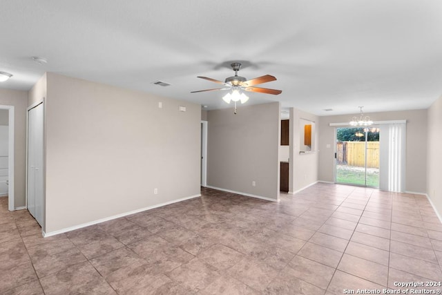 spare room with ceiling fan with notable chandelier and light tile patterned flooring