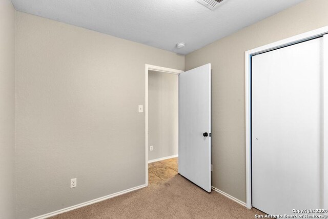 unfurnished bedroom with light colored carpet