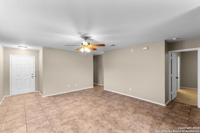 empty room featuring tile patterned flooring and ceiling fan