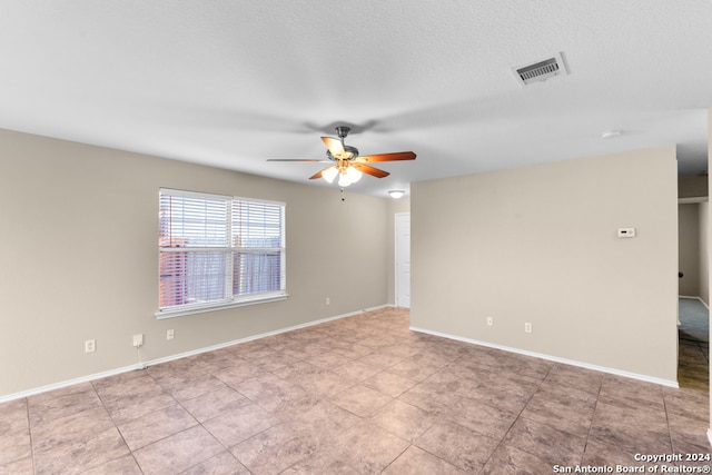 spare room with ceiling fan and light tile patterned floors