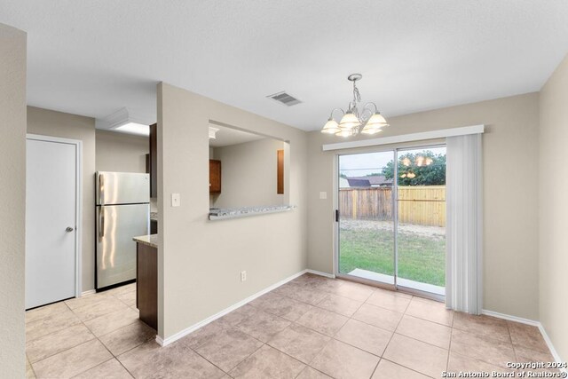 kitchen with a chandelier, stainless steel fridge, decorative light fixtures, and light tile patterned floors