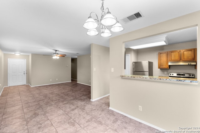 kitchen with range, light tile patterned floors, ceiling fan with notable chandelier, light stone countertops, and stainless steel fridge