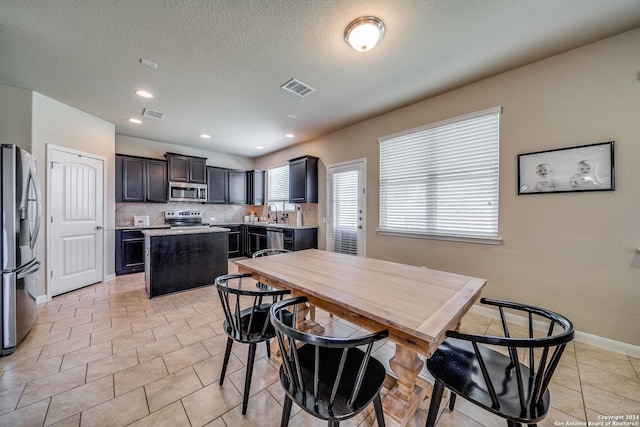 tiled dining space featuring a textured ceiling