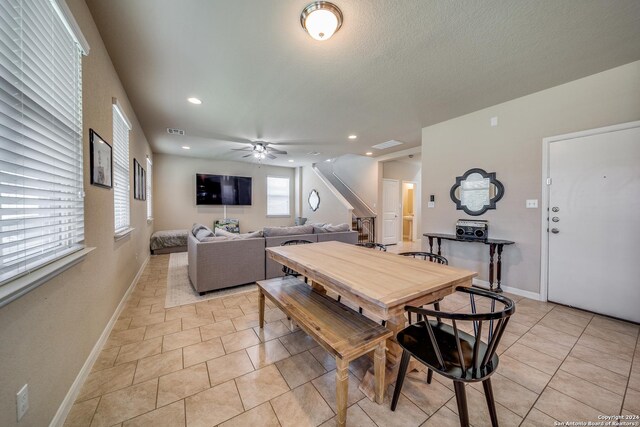 kitchen featuring ceiling fan, light stone counters, dark brown cabinetry, and a kitchen island