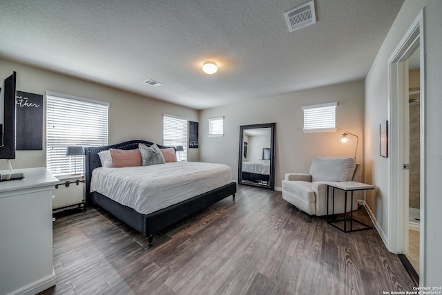 bedroom featuring dark hardwood / wood-style flooring and a textured ceiling