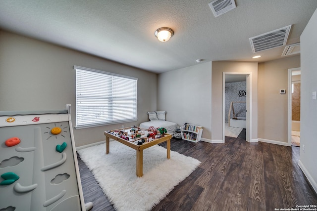 game room featuring dark hardwood / wood-style flooring and a textured ceiling