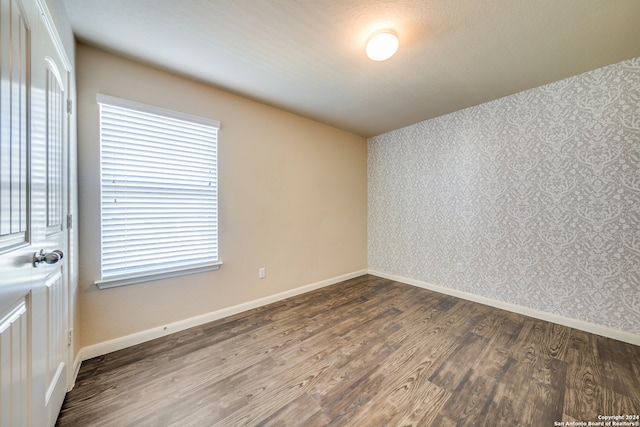 unfurnished room with a textured ceiling and hardwood / wood-style floors