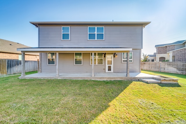 back of property with a lawn and a patio area