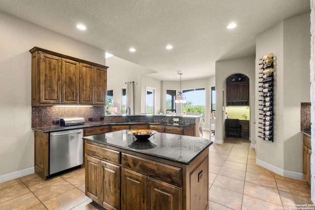 kitchen featuring kitchen peninsula, a center island, light tile patterned floors, and dishwasher