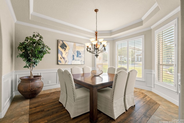 dining room with hardwood / wood-style flooring, crown molding, a tray ceiling, and a chandelier