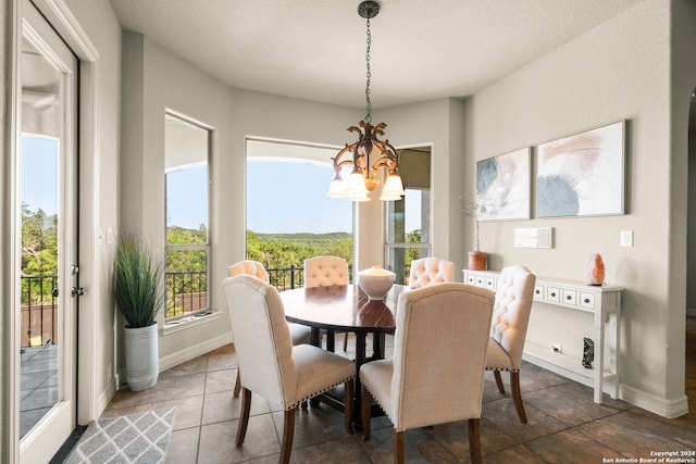 dining area featuring tile patterned flooring, a healthy amount of sunlight, and a chandelier