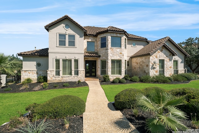 mediterranean / spanish-style home with a front yard