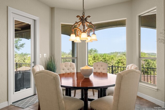 dining space featuring light tile patterned flooring and a chandelier