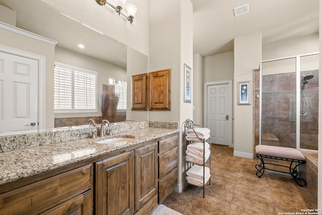 bathroom with tile patterned flooring, vanity, and walk in shower