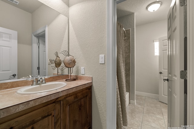 bathroom featuring tile patterned floors, a textured ceiling, shower / bath combination with curtain, and vanity