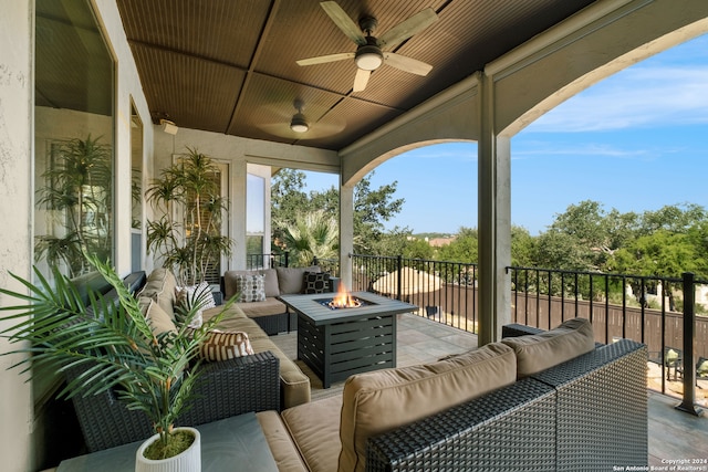 exterior space featuring ceiling fan and an outdoor living space with a fire pit