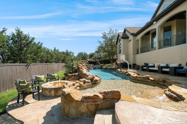 view of swimming pool featuring a patio area and a fire pit