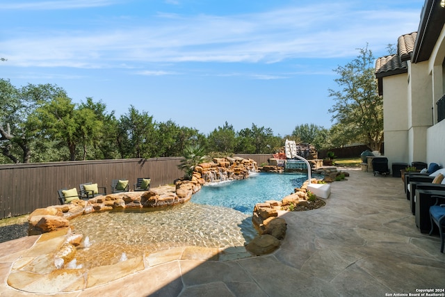 view of swimming pool with pool water feature and a patio area