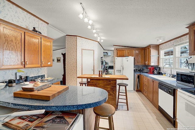 kitchen featuring dishwasher, sink, a breakfast bar area, white refrigerator with ice dispenser, and crown molding