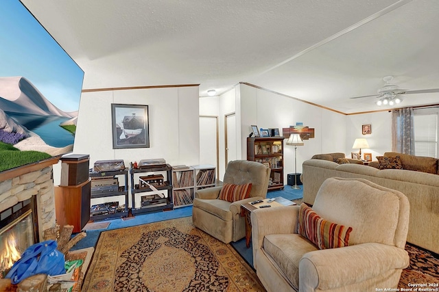 living room featuring crown molding, a stone fireplace, ceiling fan, and a textured ceiling