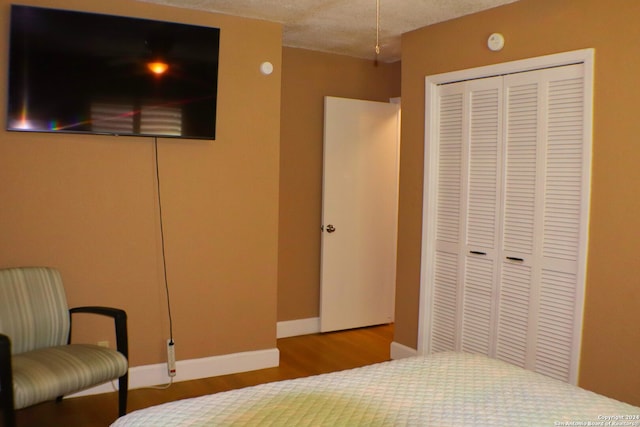 bedroom with a closet and hardwood / wood-style floors