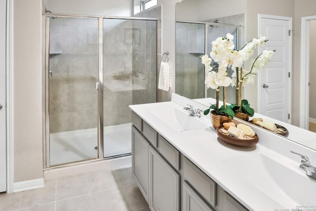 bathroom with a shower with shower door, tile patterned floors, and double vanity