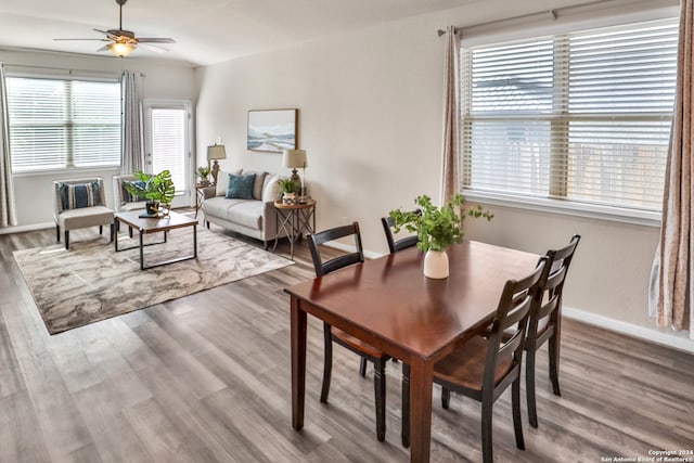 dining area with wood-type flooring and ceiling fan