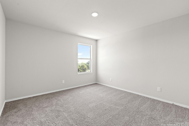 unfurnished room with carpet flooring and baseboards