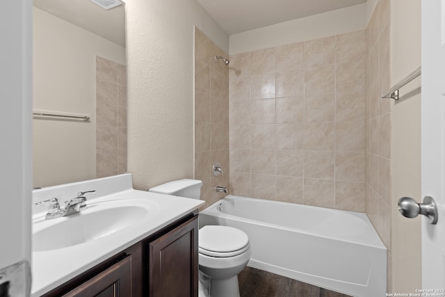 full bathroom with vanity, tiled shower / bath combo, wood-type flooring, and toilet