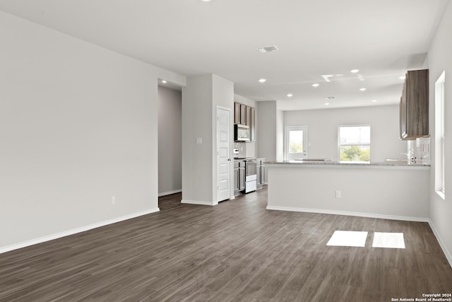 unfurnished living room featuring baseboards, visible vents, dark wood finished floors, and recessed lighting