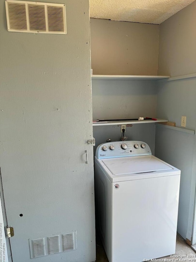 laundry room featuring washer / clothes dryer and a textured ceiling