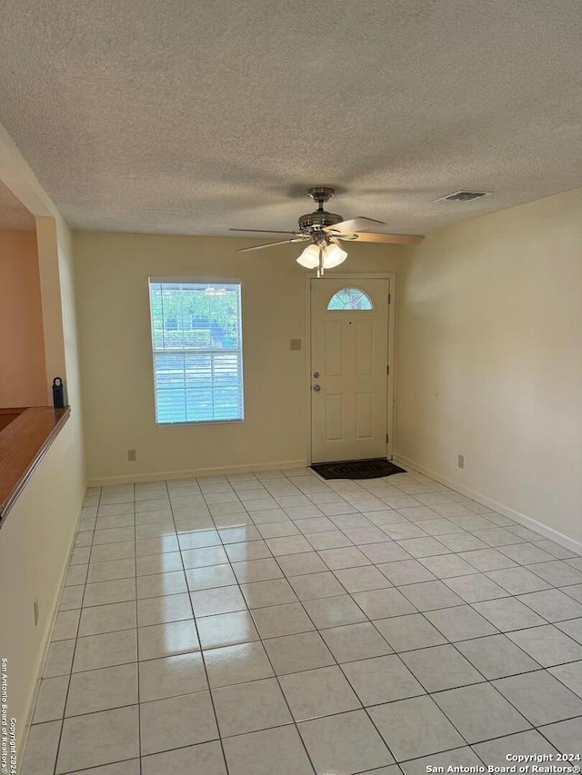 tiled spare room featuring ceiling fan and a textured ceiling