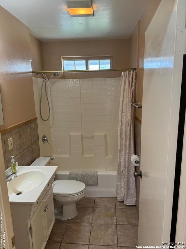 full bathroom featuring vanity, shower / bathtub combination with curtain, toilet, and tile patterned flooring