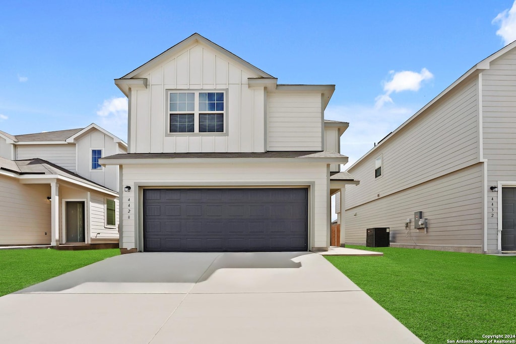 view of front of home with cooling unit, a garage, and a front lawn