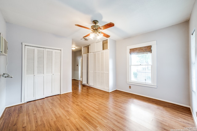 unfurnished bedroom featuring two closets, light wood-type flooring, and ceiling fan