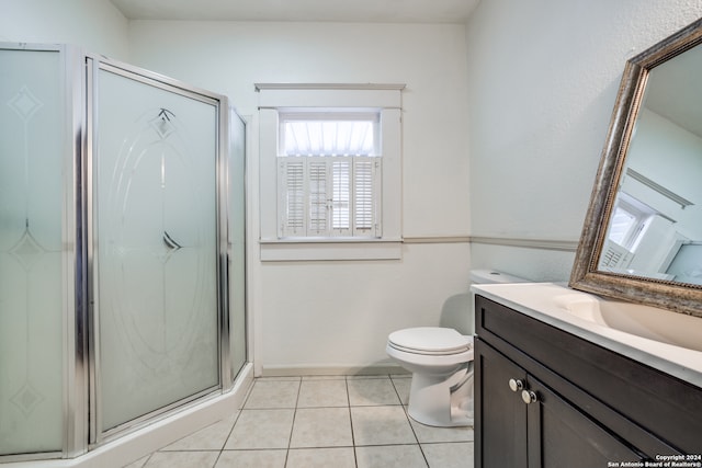 bathroom with tile patterned flooring, toilet, vanity, and an enclosed shower