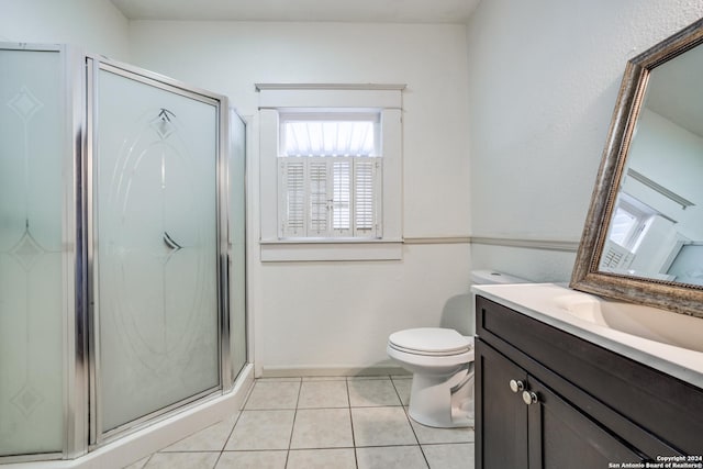 bathroom with tile patterned floors, toilet, a shower with shower door, and vanity