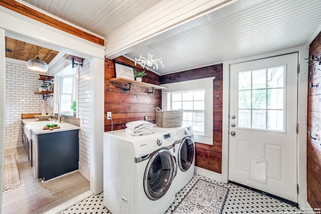 laundry room with wooden ceiling, washing machine and dryer, brick wall, and plenty of natural light