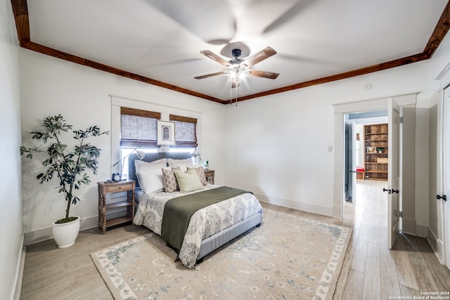 bedroom featuring hardwood / wood-style flooring, crown molding, and ceiling fan