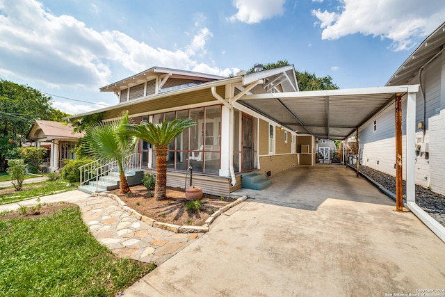 view of front facade with a carport and a sunroom