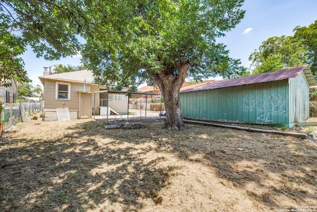 rear view of property with a storage unit