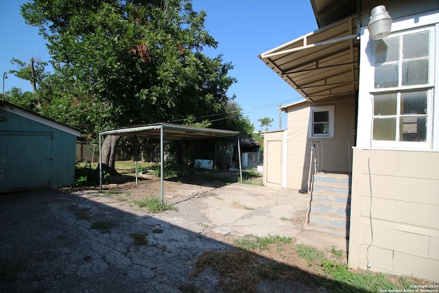 view of yard with a storage shed and a carport