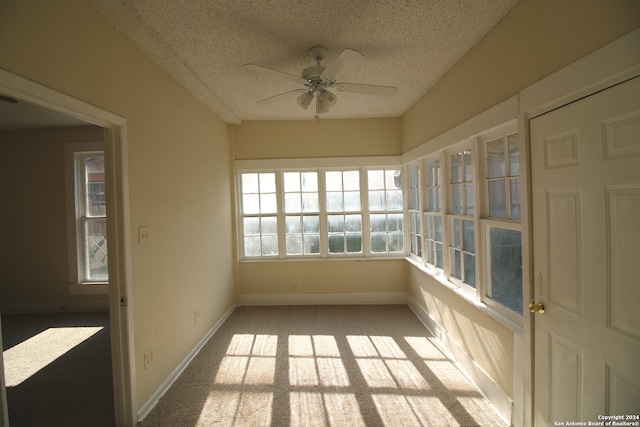 unfurnished sunroom featuring ceiling fan