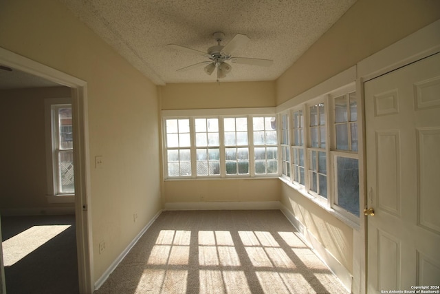 unfurnished sunroom featuring a ceiling fan