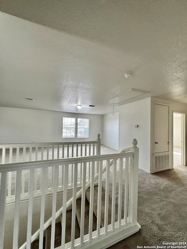 interior space featuring carpet flooring and a textured ceiling